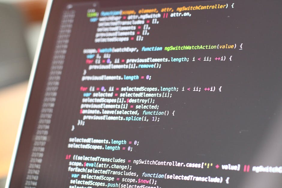A close-up view of a laptop displaying lines of code on a dark background, with various colourful syntax highlighting. Sitting beside the laptop is a ceramic coffee mug with the words 'This coffee is 